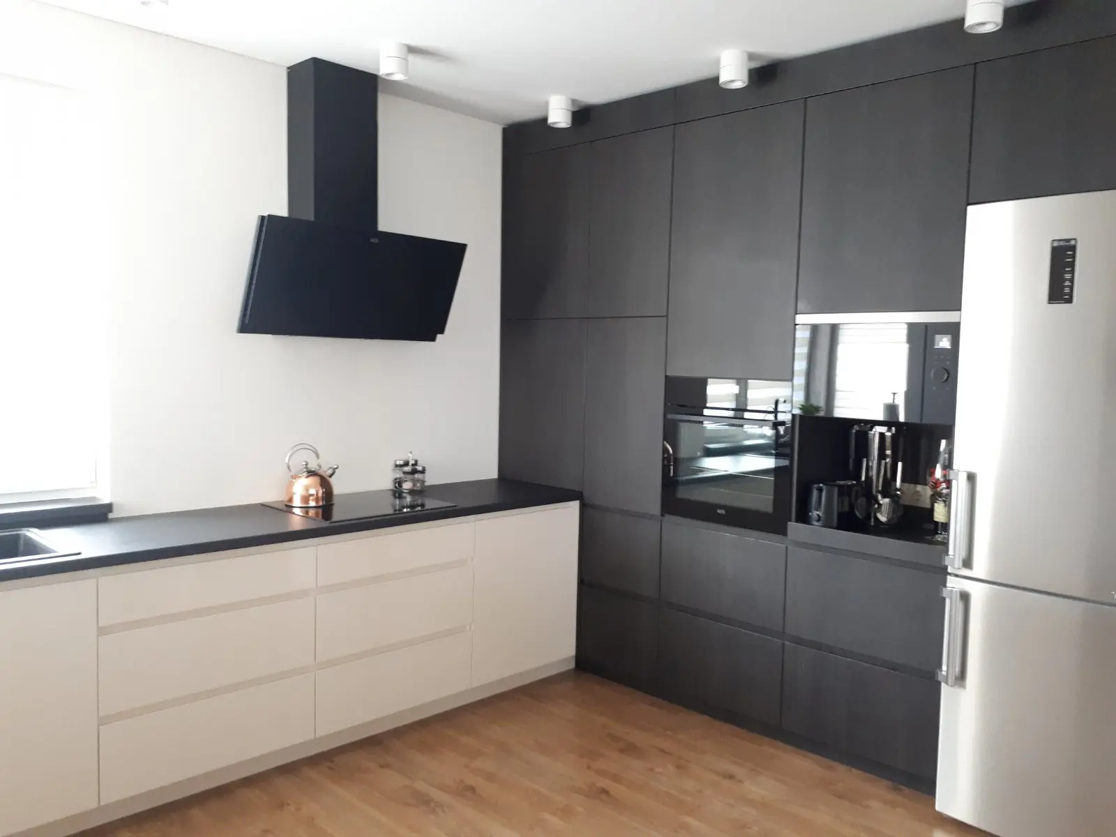 Juodos ir baltos spalvos virtuvė su kolonų siena